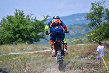 25 Haziran 2023, Veles, Makedonya. Enduro ekstrem moto yarışında sürücüler zorlu bir arazide lastiklerin üzerinden atlayarak ve dağ yollarında 40 kilometrelik bir sürüş yaparak yarıştılar..