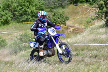 25 Haziran 2023, Veles, Makedonya. Enduro ekstrem moto yarışında sürücüler zorlu bir arazide lastiklerin üzerinden atlayarak ve dağ yollarında 40 kilometrelik bir sürüş yaparak yarıştılar..