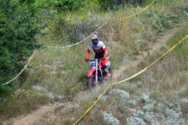 25 Haziran 2023, Veles, Makedonya. Enduro ekstrem moto yarışında sürücüler zorlu bir arazide lastiklerin üzerinden atlayarak ve dağ yollarında 40 kilometrelik bir sürüş yaparak yarıştılar..