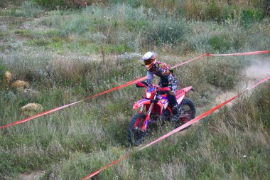 25 Haziran 2023, Veles, Makedonya. Enduro ekstrem moto yarışında sürücüler zorlu bir arazide lastiklerin üzerinden atlayarak ve dağ yollarında 40 kilometrelik bir sürüş yaparak yarıştılar..