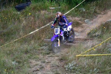 25 Haziran 2023, Veles, Makedonya. Enduro ekstrem moto yarışında sürücüler zorlu bir arazide lastiklerin üzerinden atlayarak ve dağ yollarında 40 kilometrelik bir sürüş yaparak yarıştılar..