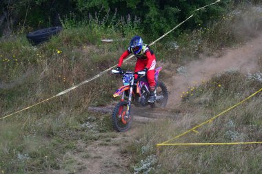 25 Haziran 2023, Veles, Makedonya. Enduro ekstrem moto yarışında sürücüler zorlu bir arazide lastiklerin üzerinden atlayarak ve dağ yollarında 40 kilometrelik bir sürüş yaparak yarıştılar..