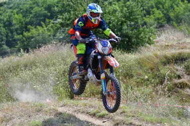 25 Haziran 2023, Veles, Makedonya. Enduro ekstrem moto yarışında sürücüler zorlu bir arazide lastiklerin üzerinden atlayarak ve dağ yollarında 40 kilometrelik bir sürüş yaparak yarıştılar..