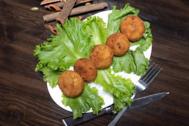 Koyu arkaplan manzaralı tavuk pirzolası ve sebzeli patates püresi.