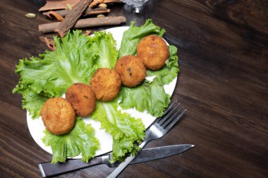 Koyu arkaplan manzaralı tavuk pirzolası ve sebzeli patates püresi.