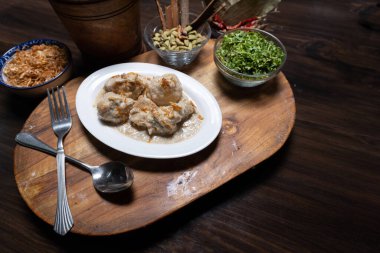 Tahta kesme tahtasında kremalı tavuk körili lokma.