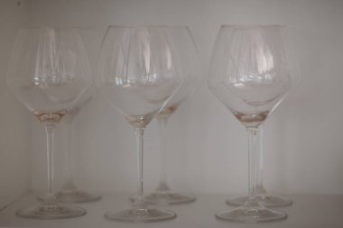 Temiz yıkanmış kristal şarap bardakları mutfakta beyaz bir rafta duruyordu. Yüksek kalite fotoğraf