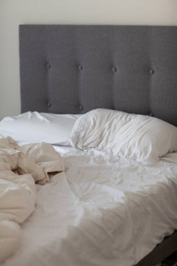 Otelde buruşuk yatak. Komik bir geceden sonra bitmemiş ya da dağınık yatağın yakın çekimi. Kullanılmış çarşaf, çarşaf ve yastıklar berbat.