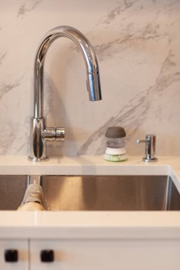 White kitchen table top stainless steel sink faucet on square marble tile wall for interior design cooking kitchen utensil display