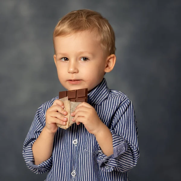 Portrait Small Boy Kid Eating Chocolate Grey Background Happy Childhood — Zdjęcie stockowe