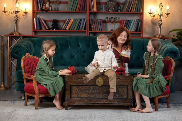 ハッピーおばあちゃんと孫が一緒に本を読んで 自宅で楽しんでいる ロイヤリティフリーのストック写真