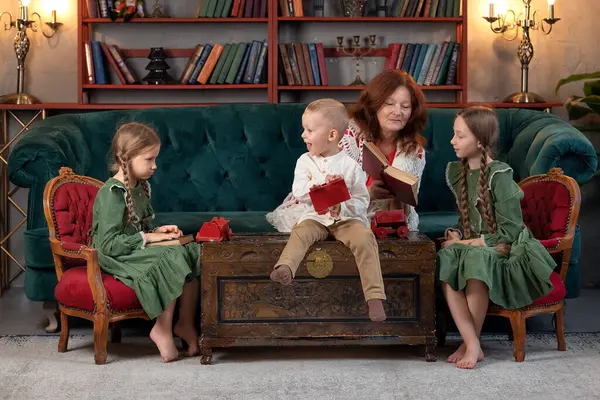 ハッピーおばあちゃんと孫が一緒に本を読んで 自宅で楽しんでいる ロイヤリティフリーのストック画像