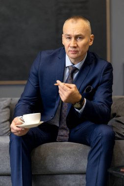 Sigara içerken takım elbiseli yakışıklı bir iş adamı.