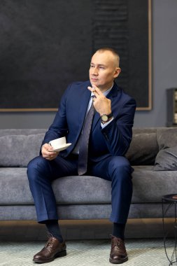 Sigara içerken takım elbiseli yakışıklı bir iş adamı.
