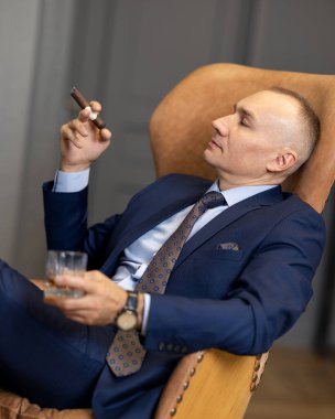 Sigara içerken takım elbiseli yakışıklı bir iş adamı.