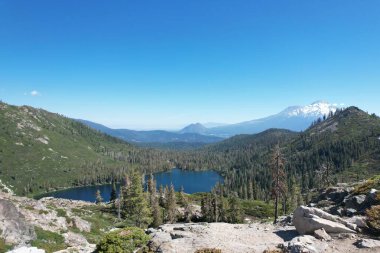 Siskiyou Gölü ve Shastha Dağı etrafındaki göl ve yabanın havadan çekilmiş fotoğrafı.