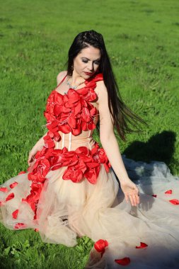 Parkta dalgalı kırmızı elbiseli güzel beyaz bir kadının fotoğrafı.