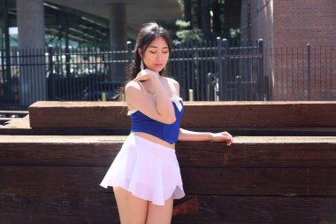 Güzel bir Asyalı Çinli kadın modelin fotoğrafı, açık havada poz veriyor.