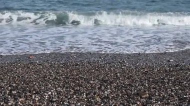 Beyaz deniz köpüklü çakıl taşı plajı ve deniz dalgaları. Akdeniz kıyısının deniz manzarası. Barselona İspanya 'nın çakıl taşlı sahilinde kıyı dalgaları. Deniz manzaralı Barceloneta 'daki ünlü Sant Miquel plajında kimse yok.