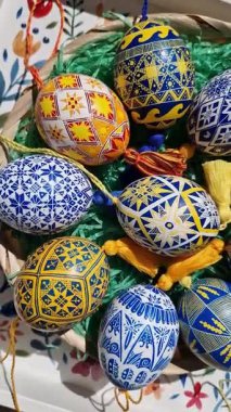 Geleneksel Paskalya kutlamalarının ruhunu somutlaştıran, yeşil çimen dolu bir sepete yerleştirilmiş karmaşık desenli, güzel tasarlanmış Ukrayna Pysanka Paskalya yumurtaları koleksiyonu..