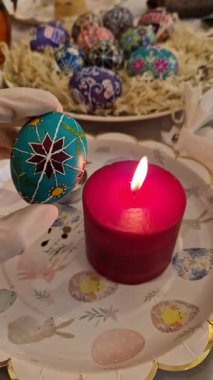 Uzman sanatçılar, geleneksel Ukrayna pisanka desenli turkuaz Paskalya yumurtası dikkatlice üretiyorlar. Balmumu tekniği detaylı tasarımlar için uygulanırken kırmızı mum da el yapımı yumurta ısıtır.