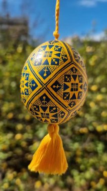 El yapımı Ukrayna piranası güneşli bir bahçede asılı duruyor. Paskalyayı geleneksel Ukrayna Paskalya yumurtasıyla kutluyoruz.