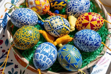 Çok güzel hazırlanmış Paskalya yumurtalarıyla dolu örülmüş bir sepet. İçinde canlı Ukrayna Pysanky tasarımları var. İlkbaharın sanatını kutlayan karmaşık desenler sergiliyor..