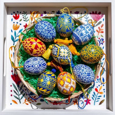 Geleneksel Ukrayna Pysanky tasarımlarıyla dolu renkli Paskalya yumurtaları, bahar şenliklerini ve canlı halk şablonlarını temsil eden güzel dekore edilmiş bir sepete konur..