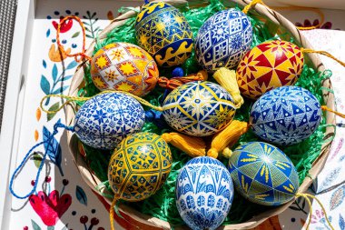 Paskalya yumurtalarından oluşan canlı bir çeşitlilikte geleneksel Ukrayna pysanky teknikleri sergilenmekte ve karmaşık halk modelleri sergilenmektedir. Paskalya kutlaması için dekoratif bir sepete güzelce yerleştirilmiş..