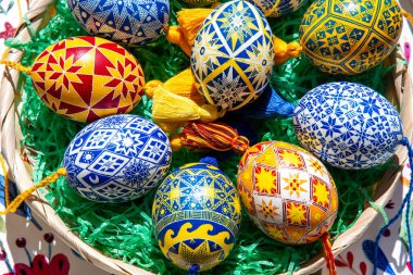 Geleneksel Ukrayna Pysanky 'sinden esinlenen renkli Paskalya yumurtaları neşeli bir Paskalya sepeti içinde karmaşık halk modelleri sergiliyor..