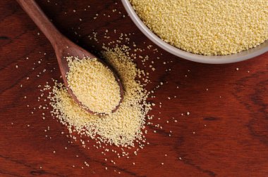 Tahta arka planda tahta kaşıkta kuskus taneleri. Üst Manzara. Metin için boşluk.