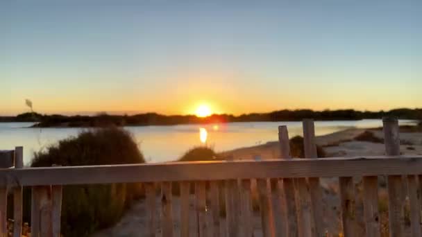 Gelassener Sonnenuntergang Über Einem Ruhigen See Der Durch Einen Holzzaun — Stockvideo