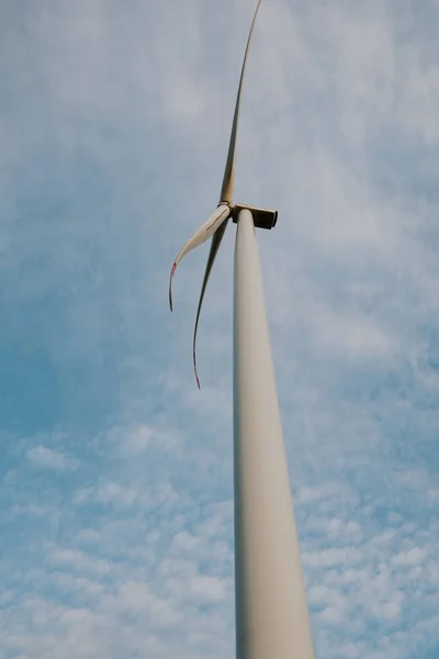 風車はきれいなエネルギーを生み出す 風力タービンは 青い空の近景に対して天然由来のプロペラで再生可能エネルギーを生成します — ストック写真