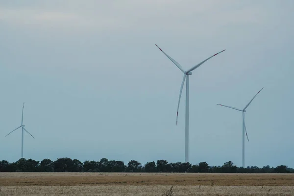 風車はきれいなエネルギーを生み出す エコフレンドリーな風力タービンは 再生可能エネルギーで農場や配電変電所を支援する電力を生み出します — ストック写真