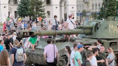 KYIV, UKRAINE - 24 Ağustos 2022: Meraklı yetişkinler ve çocuklar Meydan 'daki imha edilmiş Rus tankını inceliyor. İnsanlar Kyiv 'de askeri sergi görmek için toplandı.