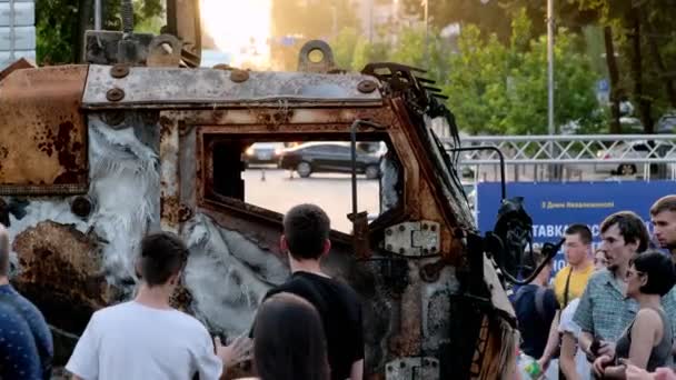 Kyiv Ukraine August 2022 人々は日没時に焼かれたロシアの軍事機器の展示を見ています 不思議な市民はキエフのスローモーションでKhreschatyk通りを歩く — ストック動画