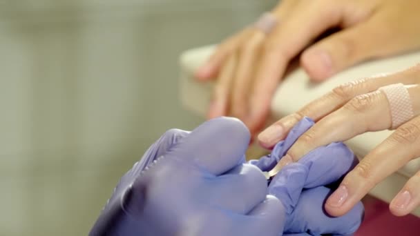 专业美容师在美容院为女性客户使用无色指甲油 主跑步刷的手穿过垫子表面特写 — 图库视频影像