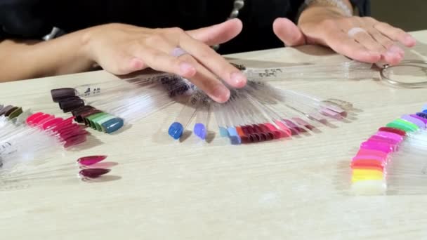 Νεαρή Πελάτισσα Επιλέγει Χρωματιστό Βερνίκι Τζελ Ξύλινο Τραπέζι Στο Σαλόνι — Αρχείο Βίντεο