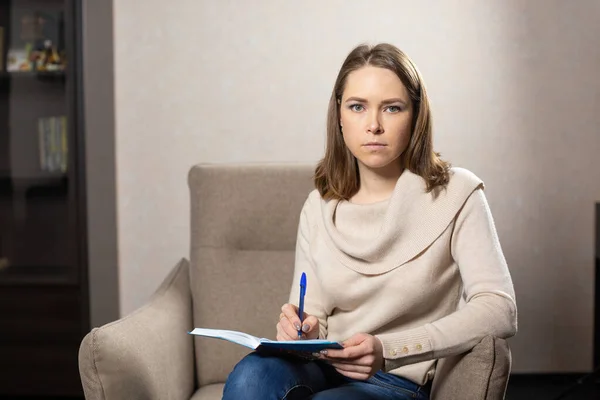 Female Psychologist Sitting Grey Armchair Looking Camera Woman Writes Notes — Stock Photo, Image