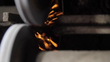 Özel daireler, endüstriyel çalışma tezgahında turuncu kıvılcımlarla keskin metal bıçakları döndürür.