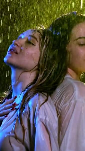 雨を注ぐの下で濡れた髪を持つ喜びの女性 赤い爪と口紅のブルネットは黄色の光の下で雨の天気をお楽しみください — ストック動画