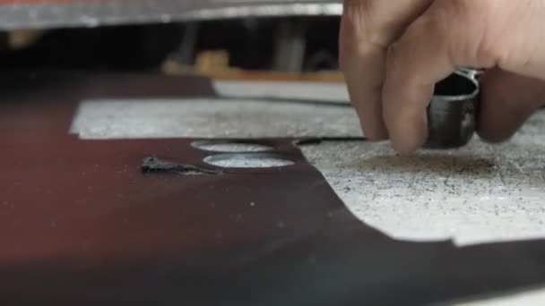Stárnoucí Krejčí Stříhá Drobné Detaily Černé Kožené Tkaniny Speciálními Kroužky — Stock video