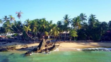Huzursuz okyanus dalgalarıyla panoramik egzotik plaj manzarası. Tropik yerlerin olağandışı doğal güzelliği kavramı yavaş çekim hava görüntüsü