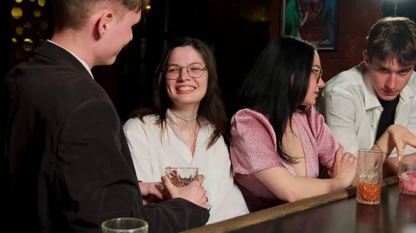 Birbirine aşık çiftler barlarda dinlenirler. Klasik elbiseli kadınlar kokteyl içer ve erkeklerle dostça sohbet ederler.