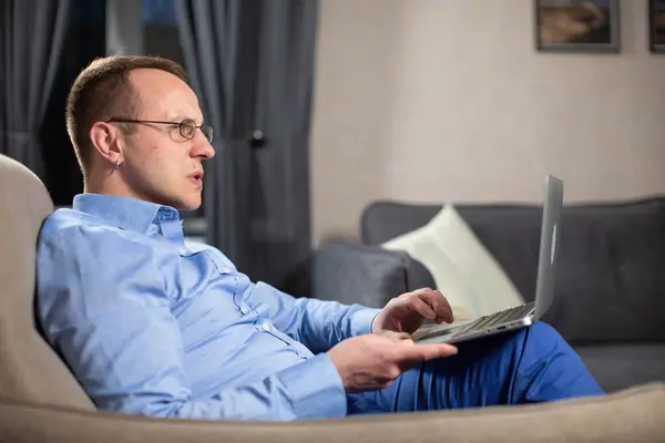 有思想的心理学家考虑解决工作任务 男医生坐在扶手椅上 膝盖上放着白色笔记本电脑 免版税图库照片