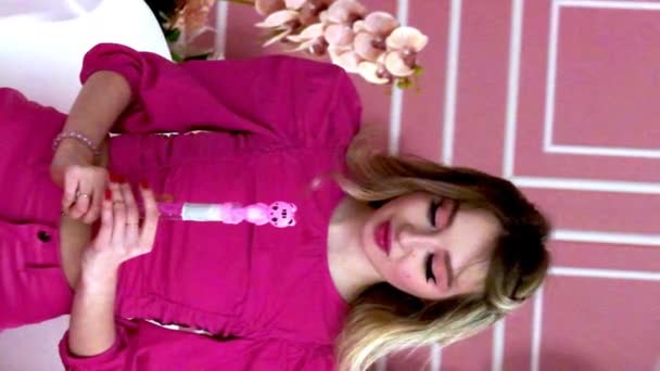 Pembe Elbiseli Canlı Pembe Rujlu Genç Bir Kadın Köpük Üflemek — Stok video