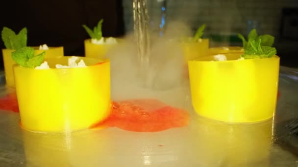 把水倒入装有干冰的花瓶里 在放置在花瓶边的填充果冻管周围制造神秘烟雾的过程 — 图库视频影像