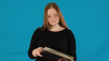 Şok olmuş genç bir kadın portföyünü açıyor ve okuduktan sonra hayal kırıklığına uğruyor. Bayan öğrenci, yavaş çekimde doküman dizinini sürükleyen hoş olmayan bir sürprizle karşılaşıyor.