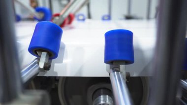 Dönen silindirler fabrika atölyesindeki plastik pencere pervazlarını kaplamak için folyo kullanırlar. Modern mobilya detaylarının endüstriyel ekipmanlarla üretilmesi
