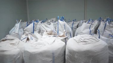 Polyester ve büyük sanayi torbalarında depolanan katkı maddeleri de dahil olmak üzere geri dönüştürülebilir malzemeler. Fabrika deposunun zeminine yerleştirilmiş kimyasallarla dolu torbalar.